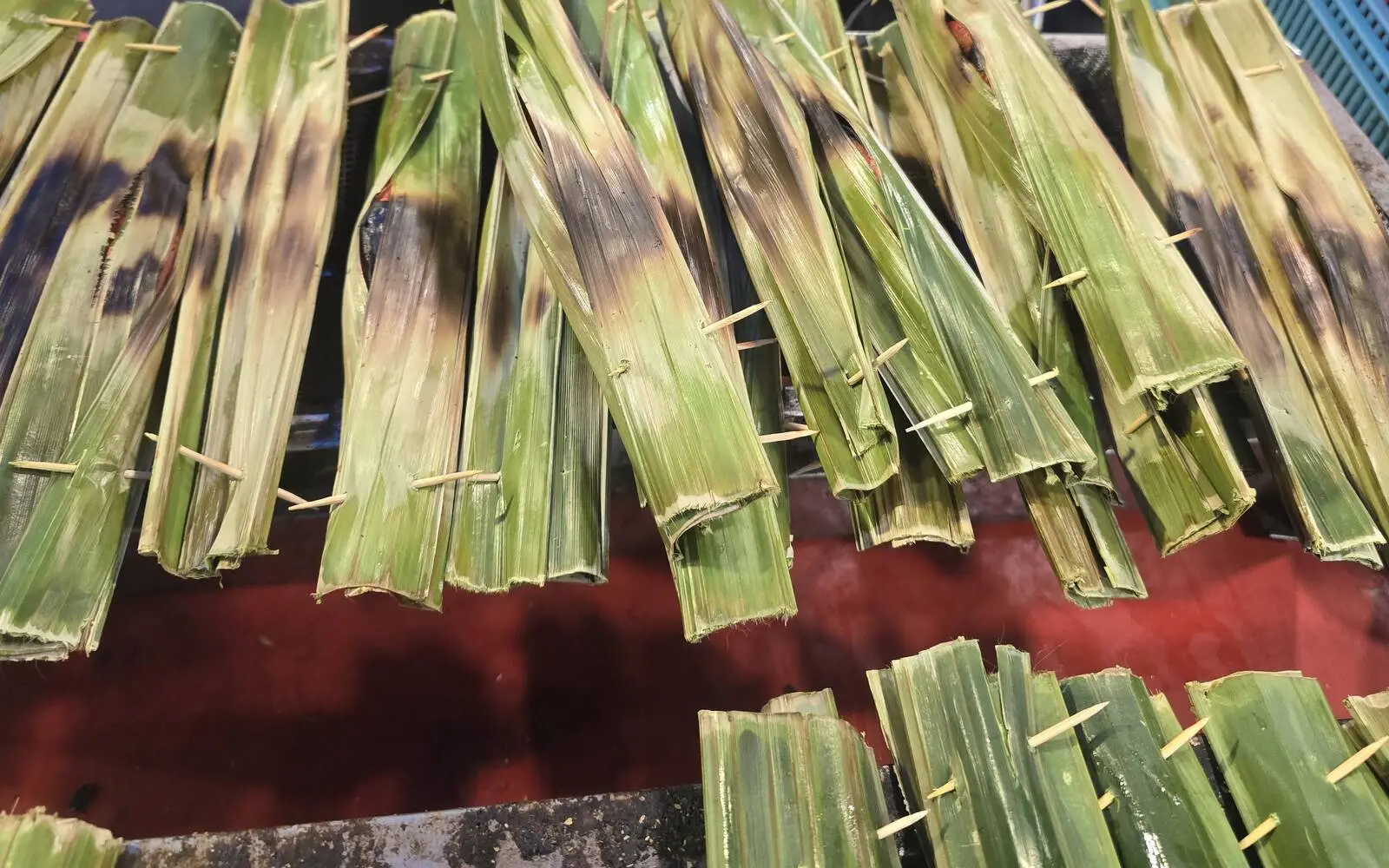 Otak-otak grilling in banana leaves at a street stall in Kuala Lumpur